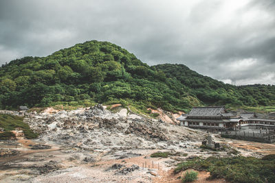 Houses on mountain against sky