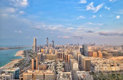 High angle view of city buildings against cloudy sky