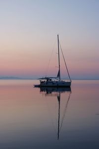 Sailboat on sea against sky during sunset