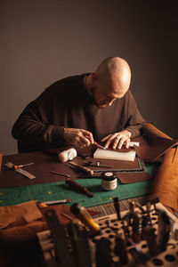 Portrait of handsome tanner man at work, small business, authentic workshop, indoors. leather goods.