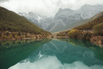 Scenic view of lake by mountains against sky