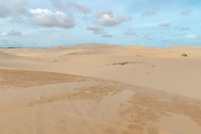 Scenic view of sand dunes against sky