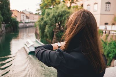 Close-up of woman checking time in city