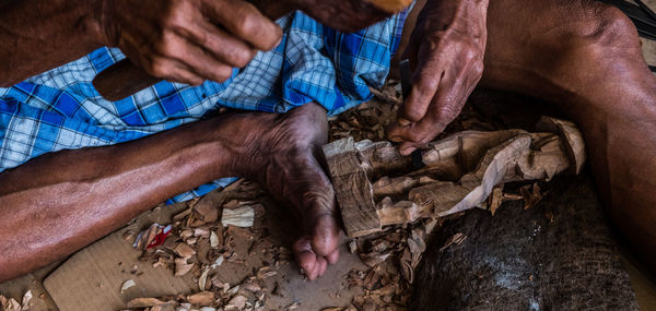 Low section of man carving wood