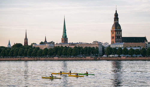 Boats in river with buildings in background