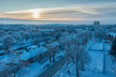 High angle view of snow covered landscape against sky during sunset