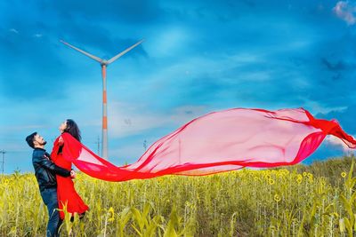 Traditional windmill on field against sky