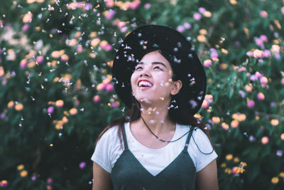 Close-up of smiling young woman against plants