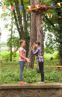 Full length of woman standing against trees