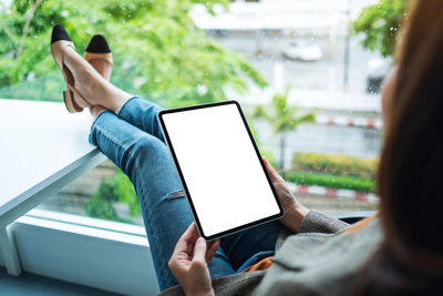 Midsection of woman using digital tablet