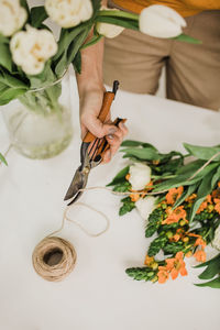 The florist collects the bouquet and ties it with a string