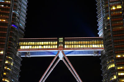 Low angle view of illuminated buildings against sky at night