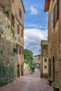 Street amidst buildings in town against sky