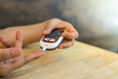 Midsection of man holding camera on table