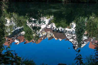 Reflection of trees in lake against blue sky