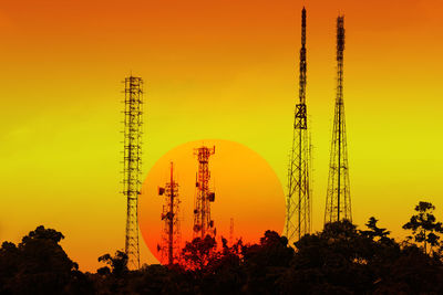 Low angle view of silhouette trees against orange sky