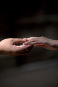 Close-up of people hand against black background