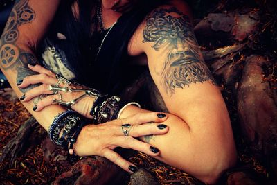 Cropped image of tattooed woman wearing bracelets