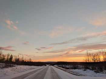 Road against sunset sky during winter.