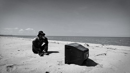 Man sitting by television set at beach