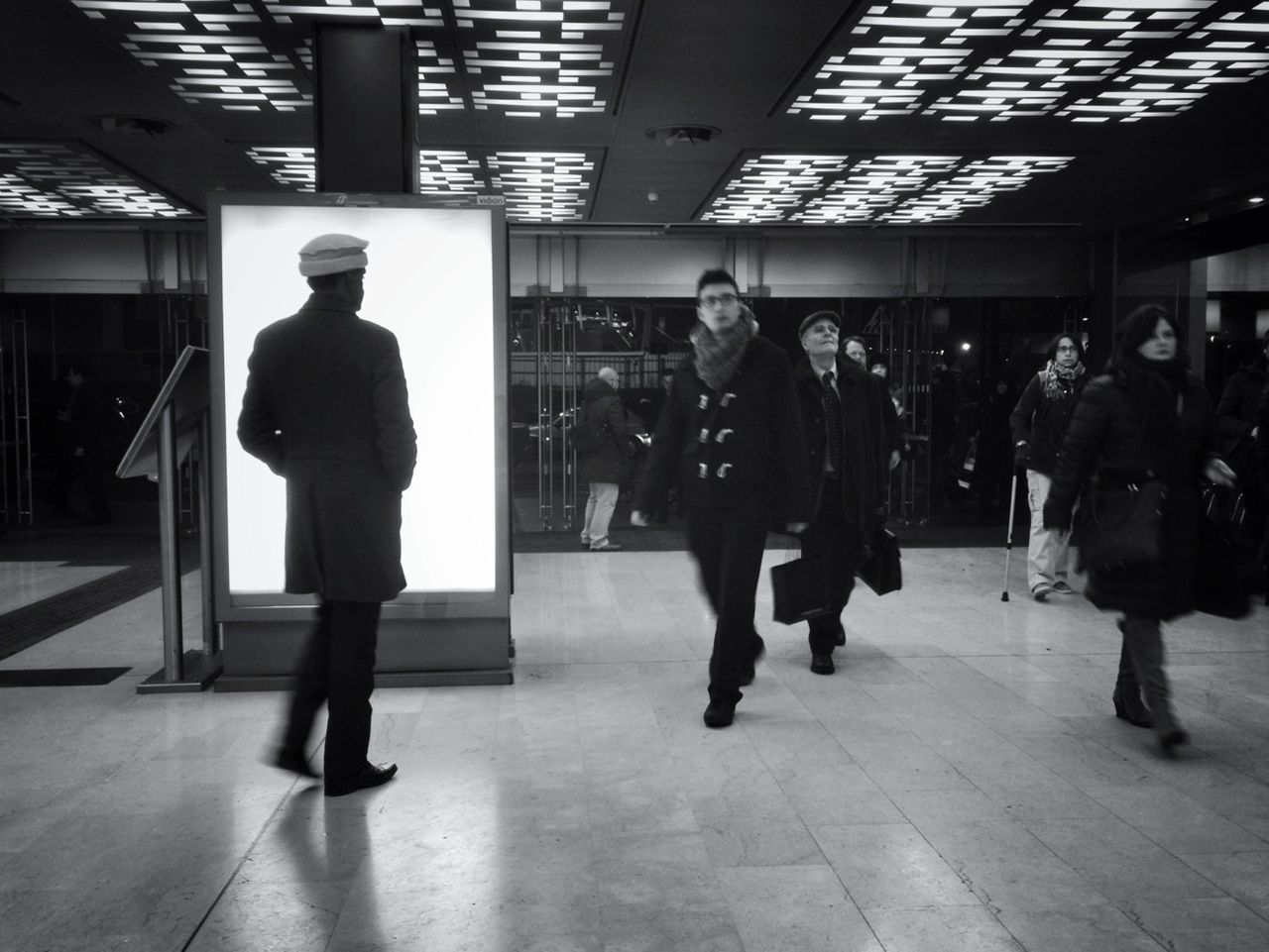 indoors, men, full length, lifestyles, walking, rear view, standing, illuminated, person, flooring, built structure, railroad station, architecture, leisure activity, railroad station platform, public transportation, passenger, city life, tiled floor