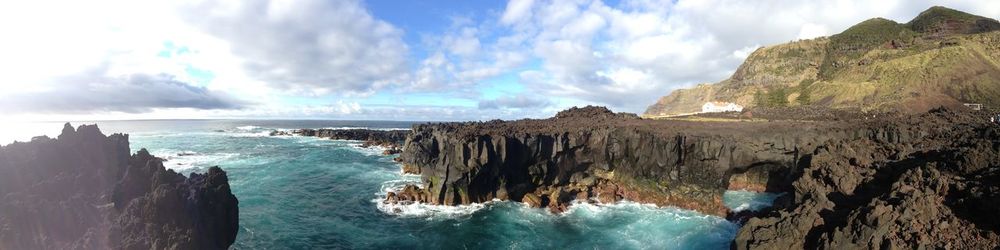 Panoramic view of sea and mountains against sky