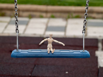 Rear view of boy sitting on swing at playground