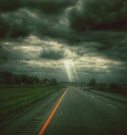 Road leading towards dramatic sky