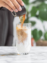 Close-up of hand holding ice cream on table