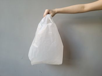 Midsection of woman holding paper against wall