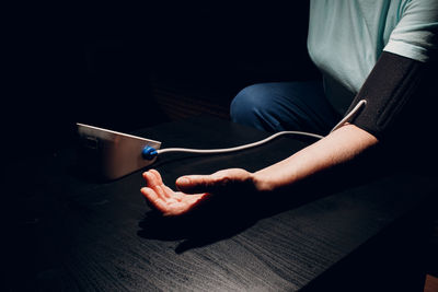 Midsection of man using mobile phone on table