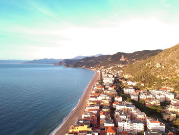 High angle view of city by sea against sky