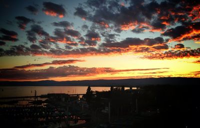 Scenic view of sea against cloudy sky at sunset