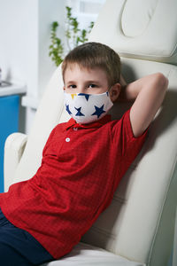 Portrait of boy sitting in mirror