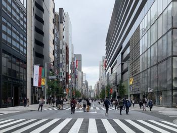 Group of people crossing road in city