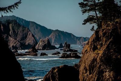 Scenic view of sea and mountains against sky