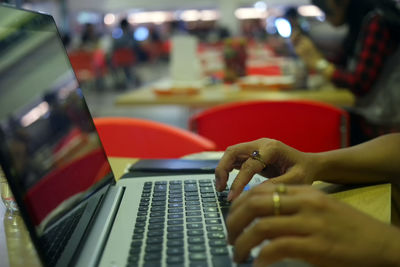 Cropped image of hand using laptop on table