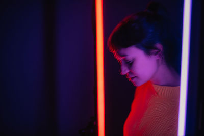 Double exposure of young woman by illuminated lighting equipment