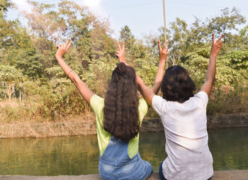 Rear view of people enjoying in lake