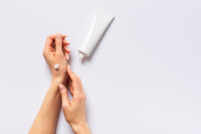 Midsection of woman holding hands against white background