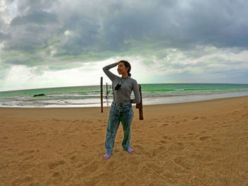 Full length of man standing on beach against sky