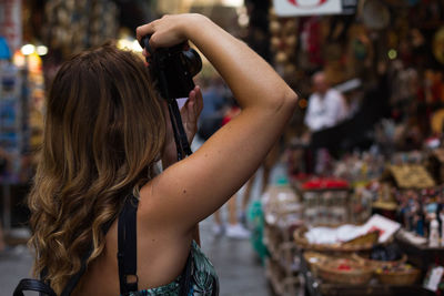 Side view of woman photographing at street market