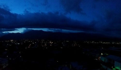 High angle view of illuminated city against sky at night