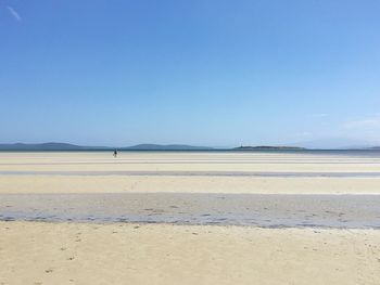 Scenic view of beach against clear blue sky