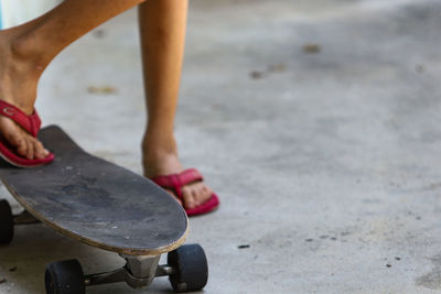 Low section of woman standing on skateboard