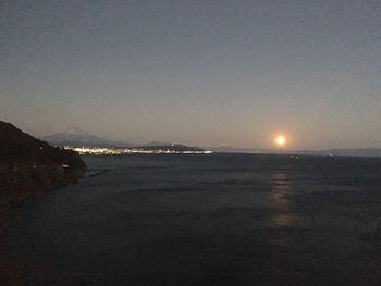 Scenic view of sea against clear sky at night