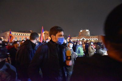 Group of people looking at crowd at night