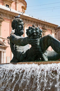 Low angle view of fountain against built structure