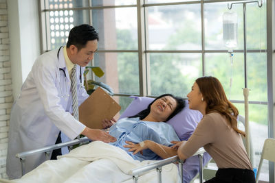 Side view of doctor examining patient at clinic