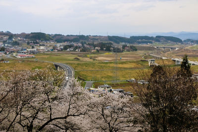 Scenic view of farm against sky in city